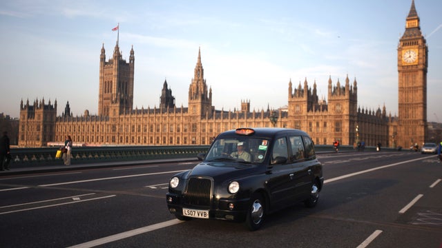 A black taxi cab makes its way over Westminster Bridge 