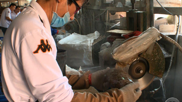 An employee at a Chinese glass factory where owners are struggling to cope with rising labor costs. 