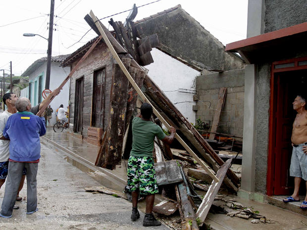 Men try to free an electrical wire wire from debris, which was turned off last night, after the passing of Hurricane Sandy in Gibara, Cuba, Thursday, Oct. 25, 2012. Hurricane Sandy blasted across eastern Cuba on Thursday as a potent Category 2 storm and h 