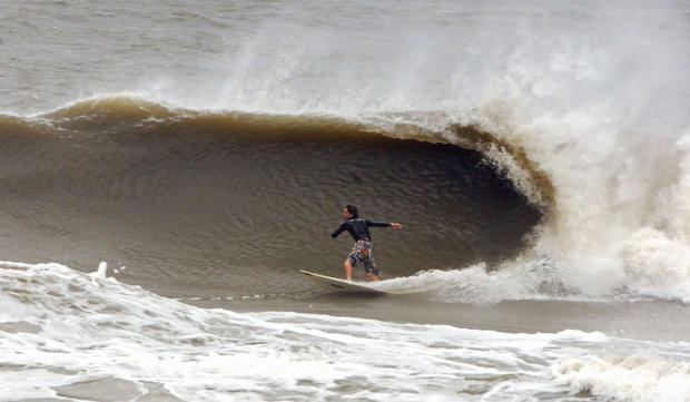 A surfer catches a large wave at the Poles, Saturday Oct. 27, 2012, in Jacksonville, Fla. 