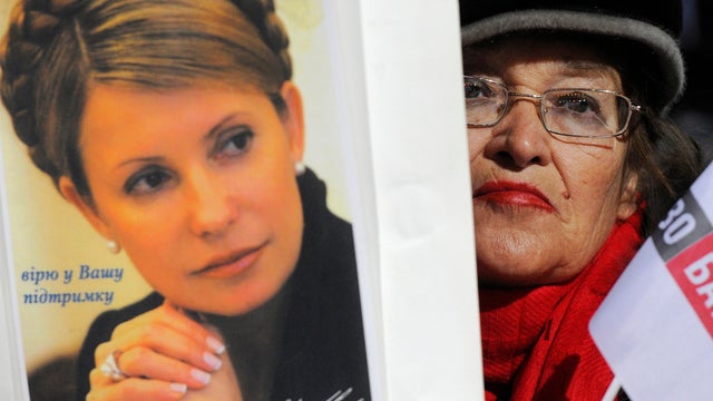 A supporter of the United Opposition party holds up a placard depicting former Ukrainian Prime Minister Yulia Tymoshenko which reads, "I believe in your support", as speakers deliver speeches during a rally in downtown Kiev, Ukraine, Friday, Oct. 26, 2012 