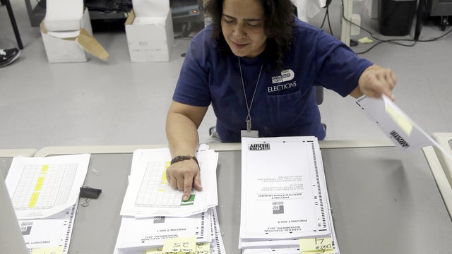 A Florida election worker checks absentee ballots 