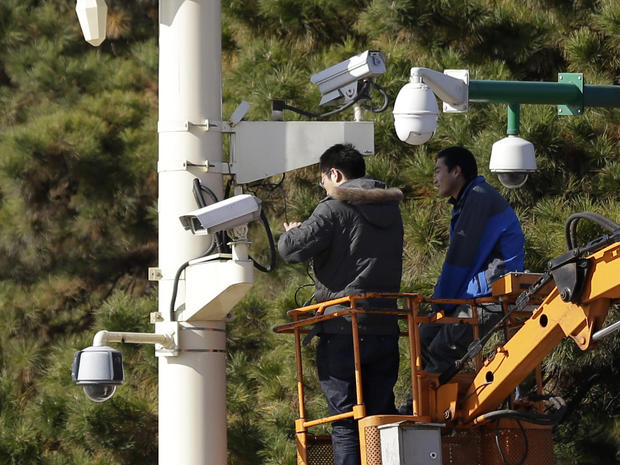 Workers check security cameras in Tiananmen Square, Beijing 