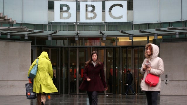 Members of the public walk outside the BBC headquarters  