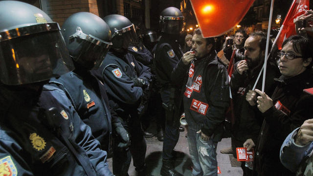 Protesters face off with police during a general strike in Madrid 