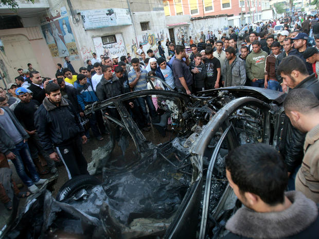 People look at the wreckage of the car of Ahmed Jabari, head of the Hamas military wing, in Gaza City after an Israeli airstrike Nov. 14, 2012. 