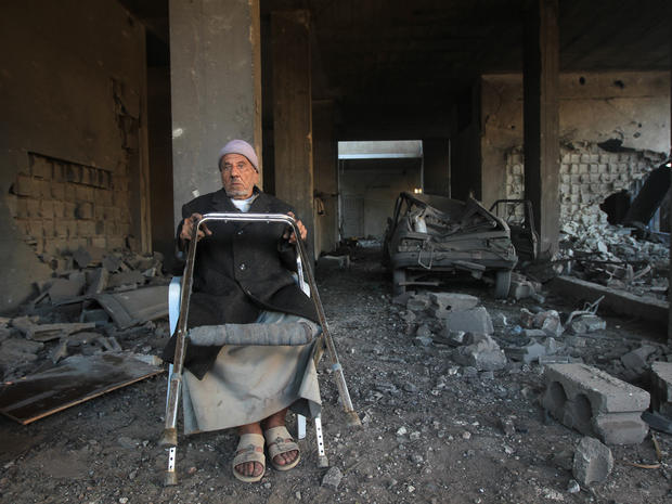 A Palestinian man sits amid rubble in his bombed house following an Israeli air strike on Gaza City 