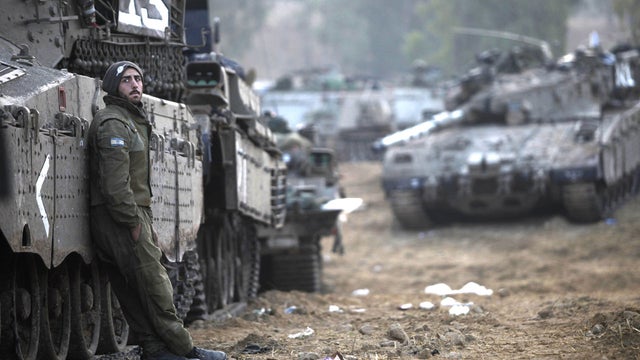 An Israeli soldier stands near tanks in a deployment area on November 19, 2012 on Israel's border with the Gaza Strip.  
