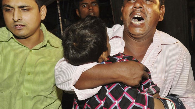 An unidentified Indian relative cries as he carries a body of a young boy who died in a stampede during Chhath Puja celebrations in Patna, India, Monday, Nov. 19, 2012.  