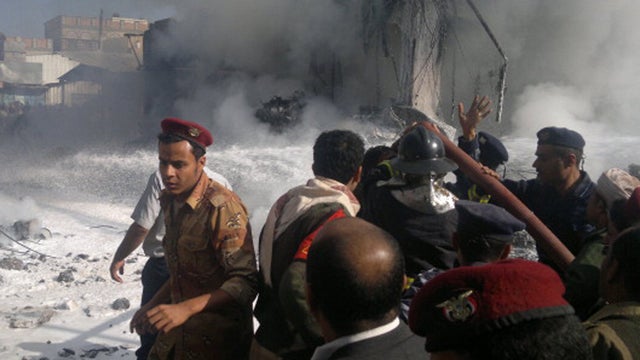 Yemeni security forces and firefighters rush to the scene of a military plane crash in Sanaa on November 21, 2012. Ten people including the pilot were killed as the Antonov jet tried to make an emergency landing when an engine failed, Yemen's defence mini 