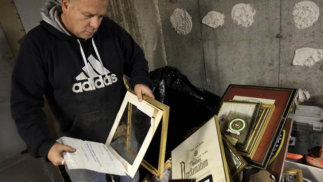 Bill Acosta sorts through his numerous diplomas, awards and other important documents in his basement office on the Rockaway Peninsula in Queens, New York, Tuesday, Nov. 27, 2012.  