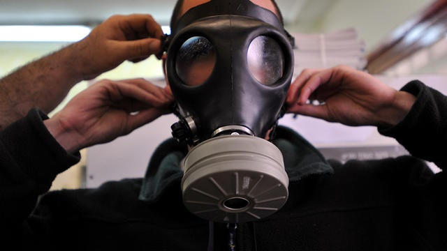 An Israeli man tries on a gas mask at a distribution center in Or-Yehuda, Israel, Feb. 28, 2010. The country has long feared that chemical or biological weapons may be used against it in a future conflict involving Iran or Syria. 