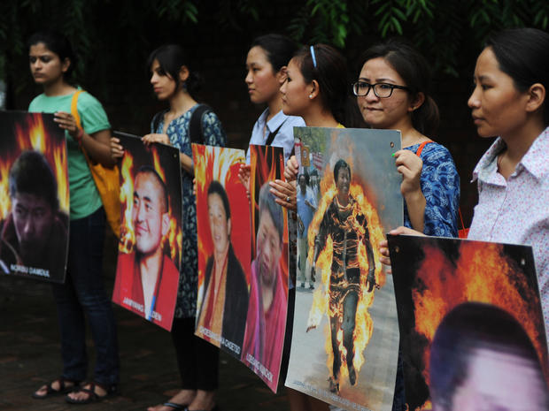 Tibetan and Indian students from Delhi university hold pictures of Tibetans who self-immolated against Chinese rule 