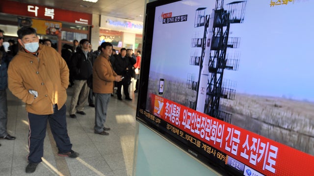 Travellers watch a TV screen broadcasting news about North Korea's rocket launch, at a railway station in Seoul on December 12, 2012. North Korea on December 12 launched a long-range rocket which Japanese authorities said passed over its southern island c 