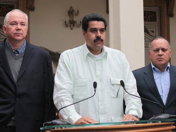 In this photo released by Miraflores Press Office, Venezuela's Vice President Nicolas Maduro, center, addresses the nation on live television flanked by Oil Minister Rafael Ramirez, left, and National Assembly President Diosdado Cabello at the Miraflores presidential palace in Caracas, Venezuela, Wednesday, Dec. 12, 2012. Maduro said that Venezuela's President Hugo Chavez will face a "complex and hard" process after undergoing his fourth cancer-related operation in Cuba on Tuesday. Over the weekend, Chavez named Maduro as his chosen political heir. 