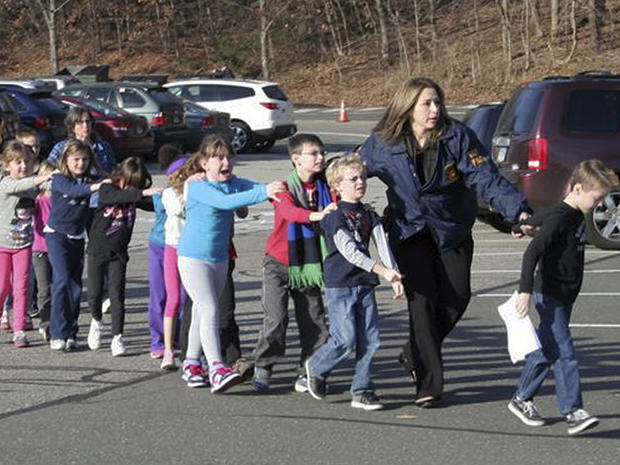 In this photo provided by the Newtown Bee, Connecticut State Police lead children from the Sandy Hook Elementary School in Newtown, Conn., following a reported shooting there Friday, Dec. 14, 2012. 