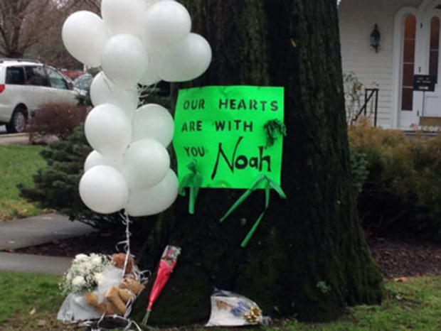 A sign for Noah Pozner hangs on tree outside funeral home 