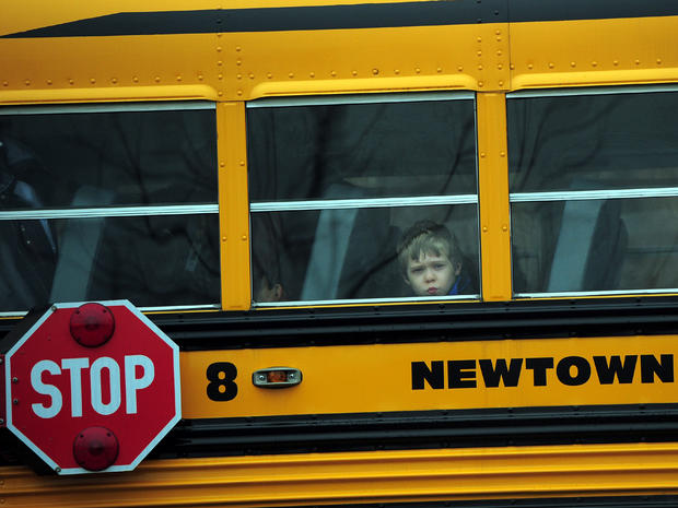 A child looks out of a bus window as it passes by St. Rose of Lima Catholic Church, where the funeral of James Mattioli, 6, was taking place Dec. 18, 2012, in Newtown, Conn. 