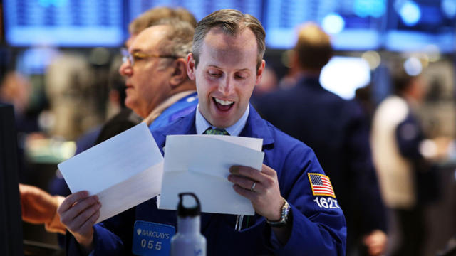 A trader smiles on Jan. 2, 2013, on the trading floor of the New York Stock Exchange in New York. 