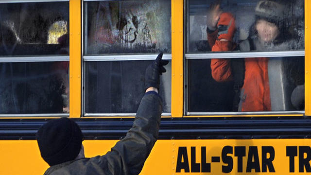 A man waves to a child on a bus on the first day of classes after the holiday break, in Newtown, Conn.,Wednesday, Jan. 2, 2013. 