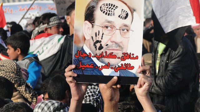 Sunni protestors hold up a portrait of Prime Minister Nuri al-Maliki 