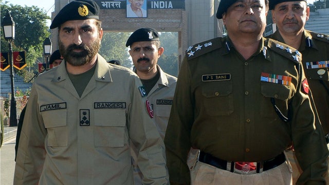 Indian and Pakistani forces walk side by side on the 2 countries' shared border 