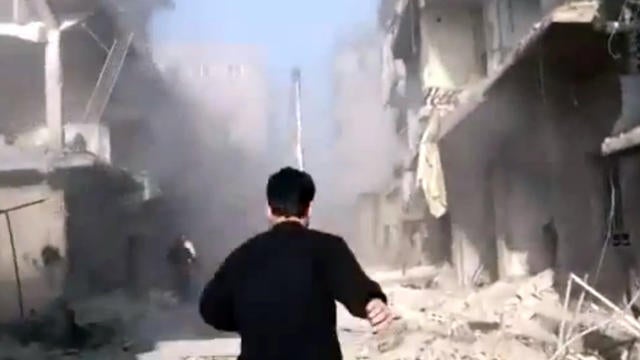 A man runs to join the rescue effort after alleged government air strikes in the Damascus suburbs 