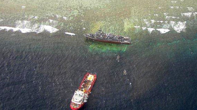 The U.S. Navy minesweeper USS Guardian, top, is seen stranded on the Tubbataha Reef, a World Heritage Site in the Sulu Sea 400 miles southwest of Manila, Philippines, Jan. 25, 2013.  