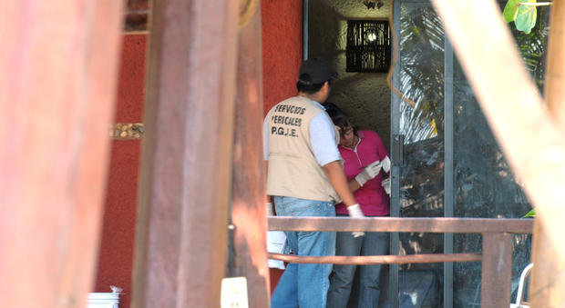Police investigators work to obtain fingerprints on a door at the home where masked, armed men broke in, in Acapulco, Mexico, Tuesday Feb. 5, 2013. According to the mayor of Acapulco, five masked men burst into this house that Spanish tourists had rented on the outskirts of Acapulco, in a low-key area near the beach, and held a group of six Spanish men and one Mexican woman at gunpoint, while they raped the six Spanish women before dawn on Monday. 