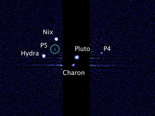 This image, taken by NASA's Hubble Space Telescope, shows five moons orbiting the distant, icy dwarf planet Pluto. The green circle marks the newly discovered moon, designated P5, as photographed by Hubble's Wide Field Camera 3 on July 7, 2012. 