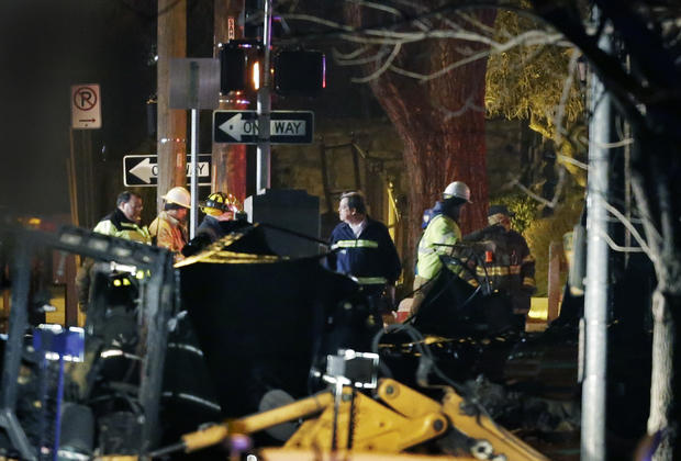 Workers inspect a building that exploded and caught fire in the Plaza shopping district of Kansas City 
