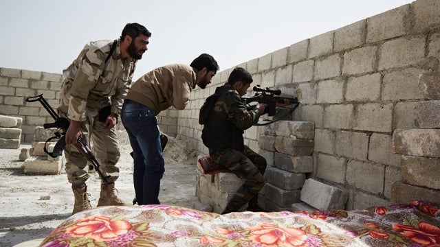 Flames rise from a house from Syrian government shelling, at Baba Amr neighborhood in Homs province 