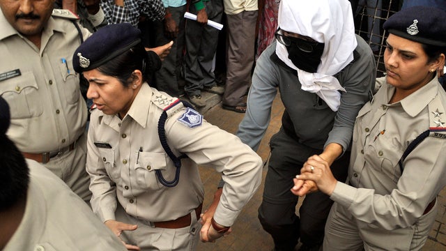 A Swiss woman, center, who, according to police, was gang-raped by a group of eight men while touring by bicycle with her husband, is escorted by policewomen for a medical examination at a hospital in Gwalior, India, March 16, 2013. 