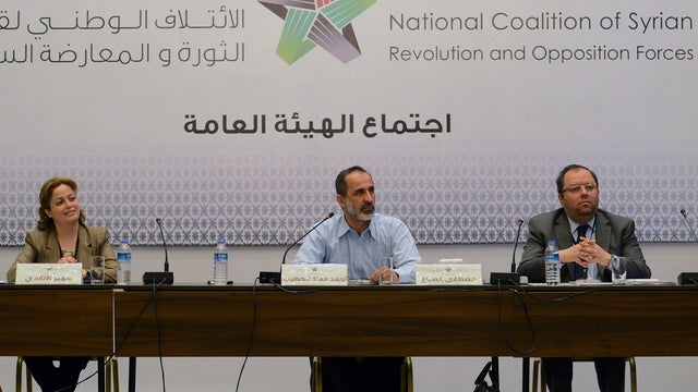 Head of the Syrian National Coalition for Opposition and Revolutionary Forces Mouaz al-Khatib, center, sits with other members 