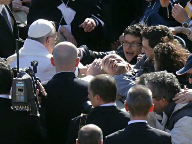 Pope Francis blesses a disabled man prior to his inaugural Mass 