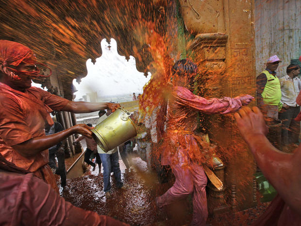 Villagers from Nandgaon, India, throw colored water on the villagers from Barsana as they arrive at the Nandagram temple, famous for Lord Krishna and his brother Balram, during Lathmar Holi festival in Nandgaon, 75 miles from New Delhi, March 22, 2013. Du 