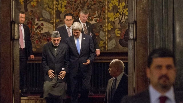 U.S. Secretary of State John Kerry (in blue tie) and Afghanistan's President Hamid Karzai walk down flight of stairs after bilateral meeting before news conference at presidential palace in Kabul March 25, 2013. 