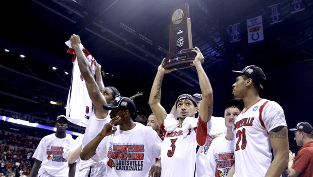Louisville guard Peyton Siva (3) holds up the regional trophy as Louisville players celebrate their 85-63 win over Duke in the Midwest Regional final in the NCAA college basketball tournament, Sunday, March 31, 2013, in Indianapolis. 