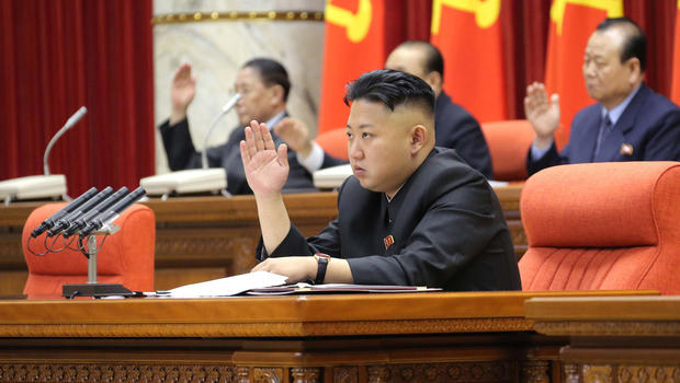 In this Sunday, March 31, 2013 photo released by the Korean Central News Agency (KCNA) and distributed in Tokyo Monday, April 1, 2013 by the Korea News Service, North Korean leader Kim Jong Un raises his hand with other officials to adopt a statement during a plenary meeting of the central committee of the ruling Workers' Party in Pyongyang, North Korea. 