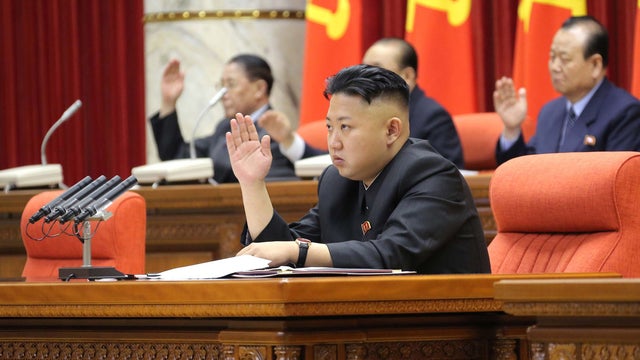 In this Sunday, March 31, 2013 photo released by the Korean Central News Agency (KCNA) and distributed in Tokyo Monday, April 1, 2013 by the Korea News Service, North Korean leader Kim Jong Un raises his hand with other officials to adopt a statement duri 