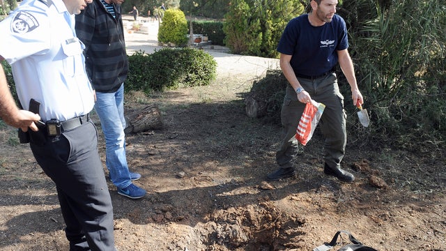 Israeli bomb technician collects remains of rocket launched from Gaza Strip that fell close to town of Sderot on April 3, 2013. 