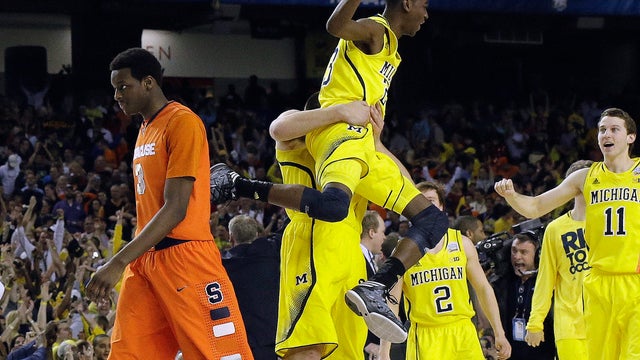 Michigan's Caris LeVert (23) celebrates with teammates as Syracuse's Jerami Grant (3) walks off the court during the second half of a NCAA Final Four tournament college basketball semifinal game April 6, 2013, in Atlanta. Michigan won 61-56. 