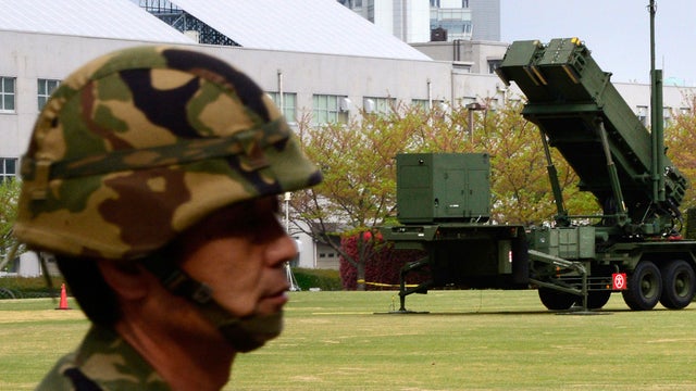 A Japanese soldier walks past Patriot Advanced Capability-3 missile launchers deployed at the Defense Ministry in Tokyo April 10, 2013. 