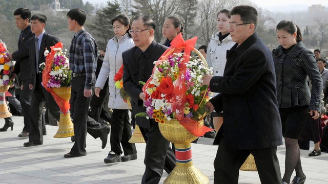 North Koreans carry flowers to giant statues of North Korean late leaders Kim Il Sung and Kim Jong Il at Mansu Hill in Pyongyang, North Korea, April 15, 2013 as their nation celebrates 101st birth anniversary of national founder Kim Il Sung, its most impo 