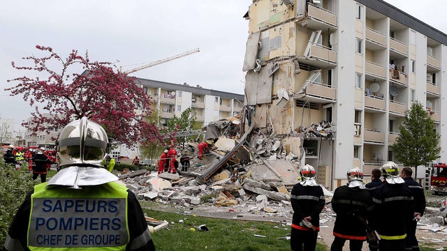 French firemen attend the scene of a building hit by an explosion that caused the collapse of its inside floors, in Reims, eastern France, Sunday, April 28, 2013. At least three people were killed and 14 others injured, according to officials.  