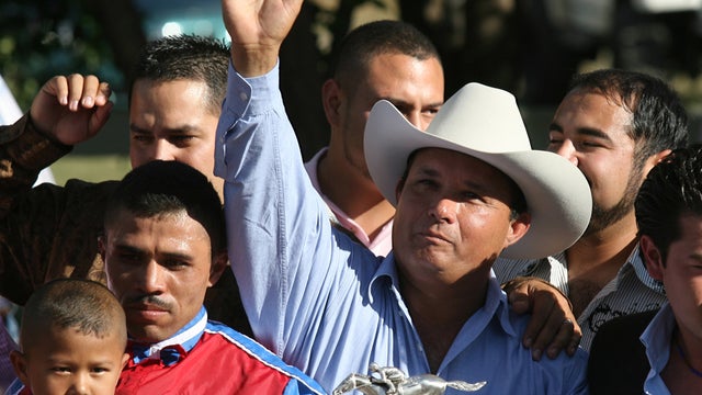 In this Sept. 6, 2010 file photo, owner Jose Trevino Morales, center, acknowledges the crowd as he stood with the trophy after Mr. Piloto won the All American Futurity horse race at Ruidoso Downs, N.M. Prosecutors told a federal jury on Wednesday, May 8,  