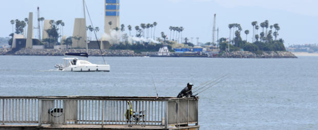 A man fishes off the pier in front of on 