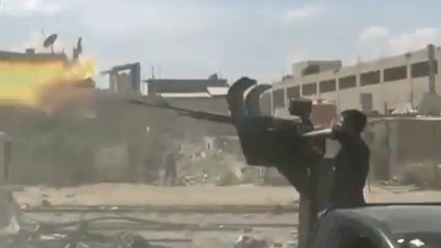 Rebels clash with government troops near a checkpoint in the al-Matahen suburb of Damascus 