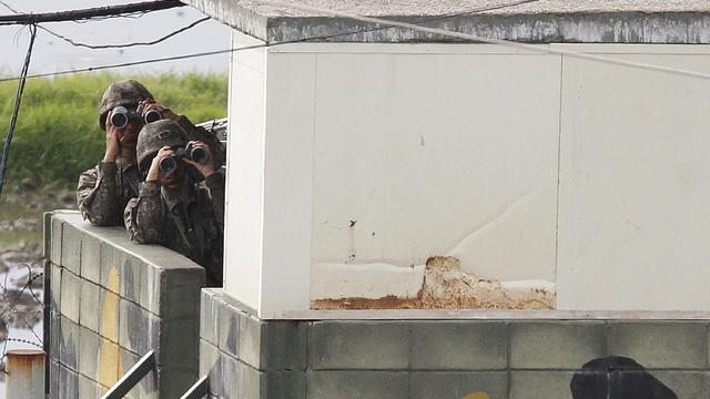 South Korean soldiers look through binoculars at the North 