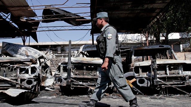 An Afghan police officer investigates the aftermath of a suicide attack and gun battle at the International Red Cross building in Jalalabad, Afghanistan, May 30, 2013. 